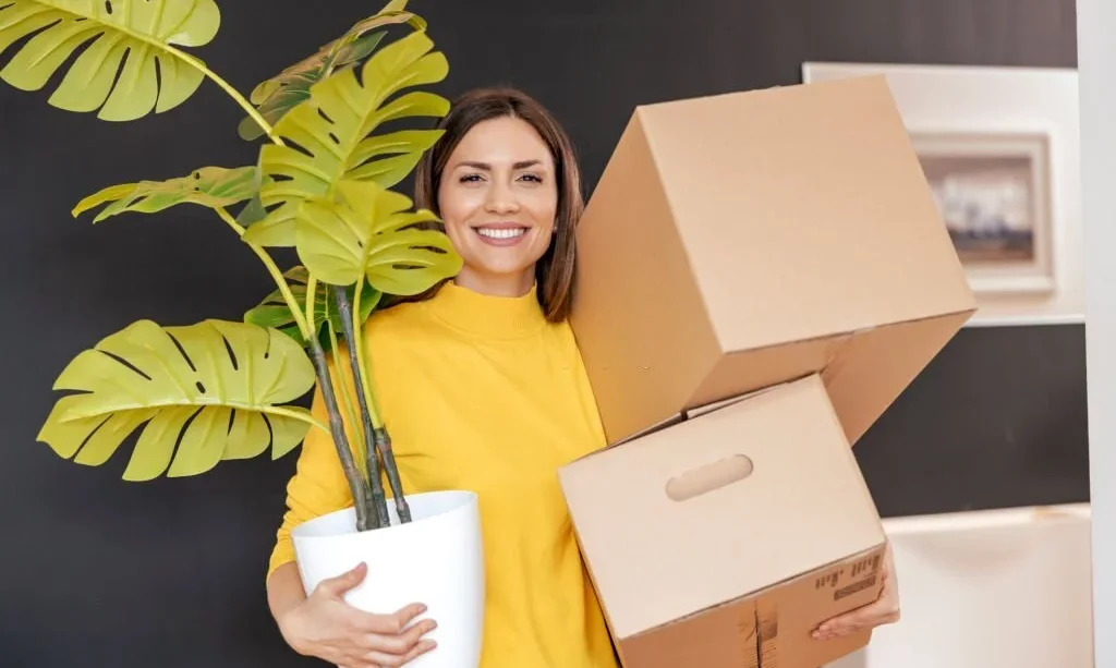 woman with plant and carboard boxes