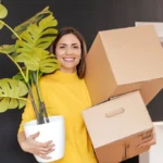woman with plant and carboard boxes