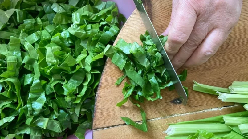 hand chopping fresh chards on the cutting board