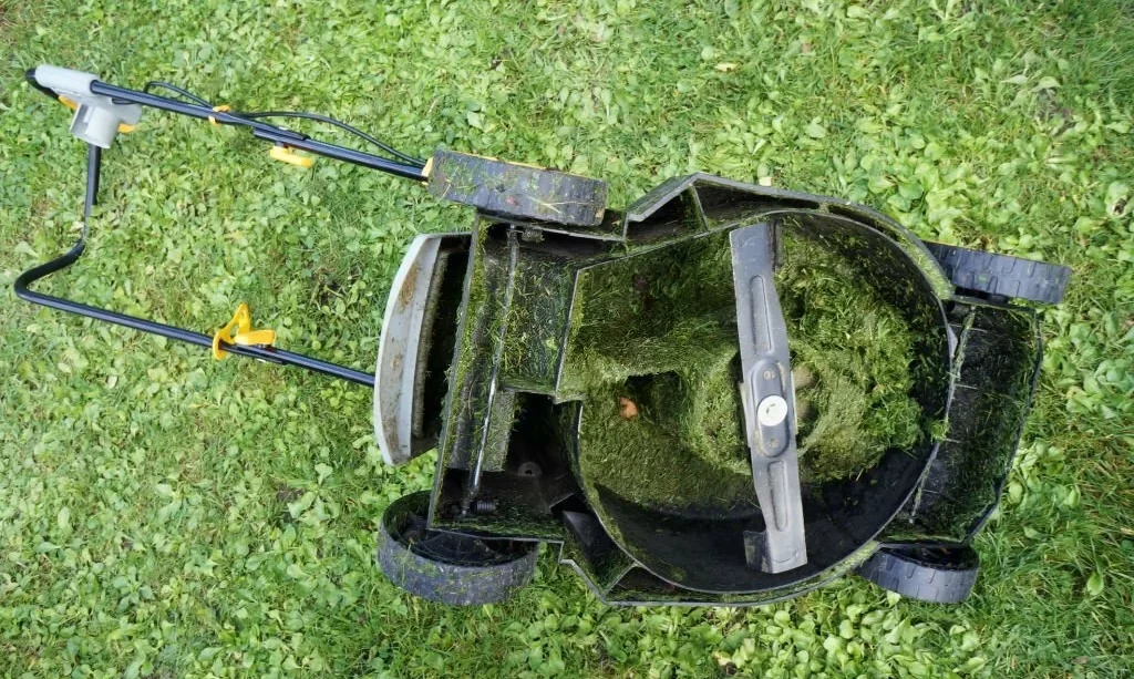 lawn mower's entire mechanism is clogged with wet cut grass