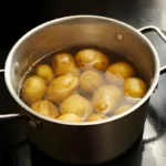 Potatoes with peel in a stainless steel pot